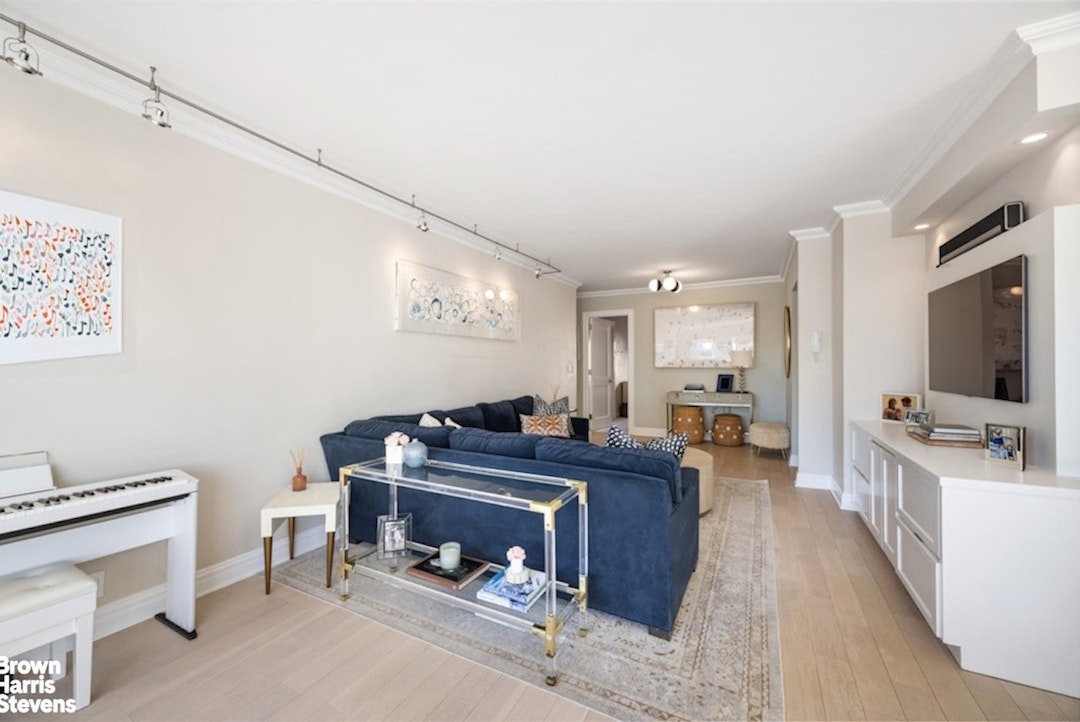 370 East 76th Street, Unit A1002 Manhattan, NY 10021 - Photo 2 of 13 a living room with furniture and a flat screen tv