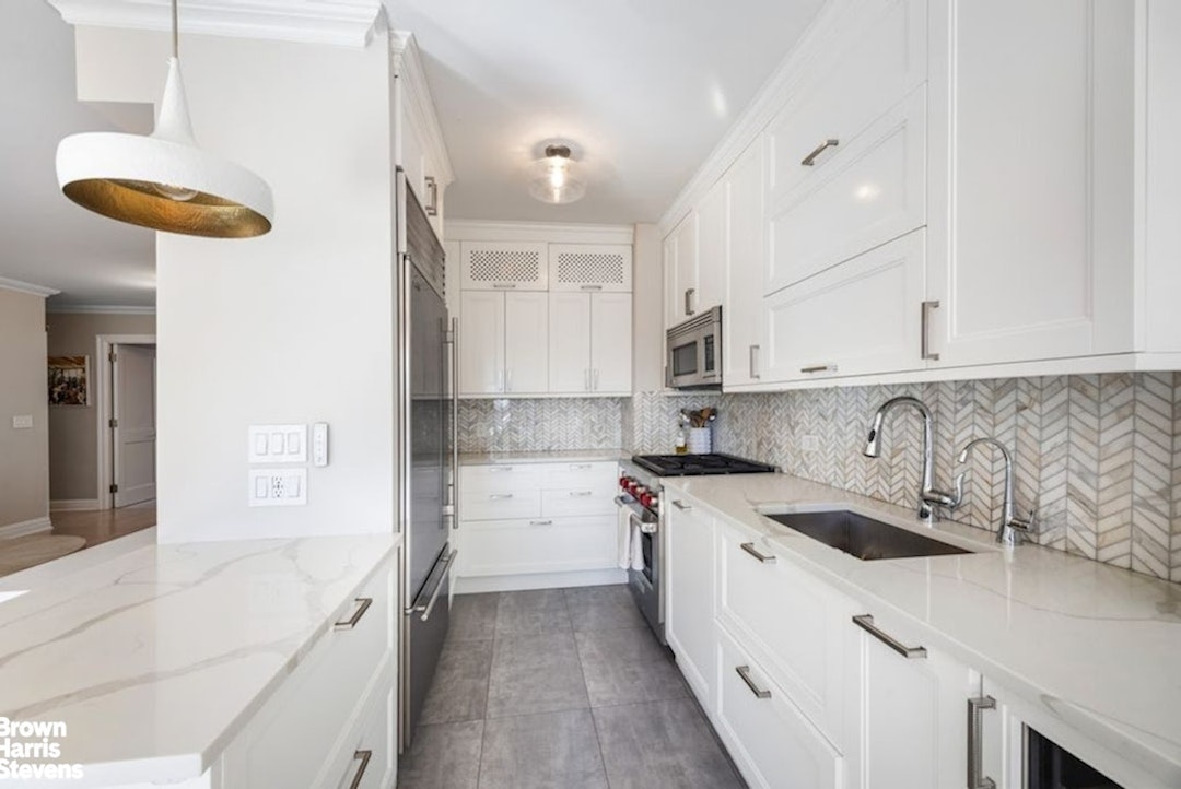 370 East 76th Street, Unit A1002 Manhattan, NY 10021 - Photo 4 of 13 a kitchen with a sink a stove and cabinets
