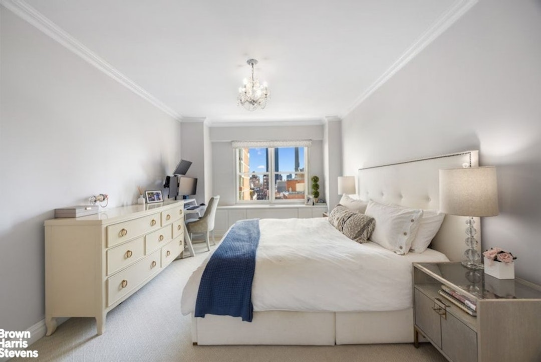 370 East 76th Street, Unit A1002 Manhattan, NY 10021 - Photo 5 of 13 a spacious bedroom with a bed and a lamp