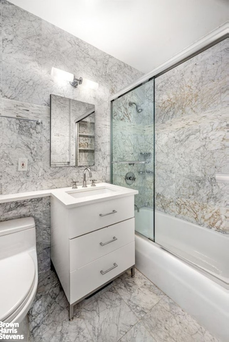 370 East 76th Street, Unit A1002 Manhattan, NY 10021 - Photo 6 of 13 a bathroom with a double vanity sink and mirror