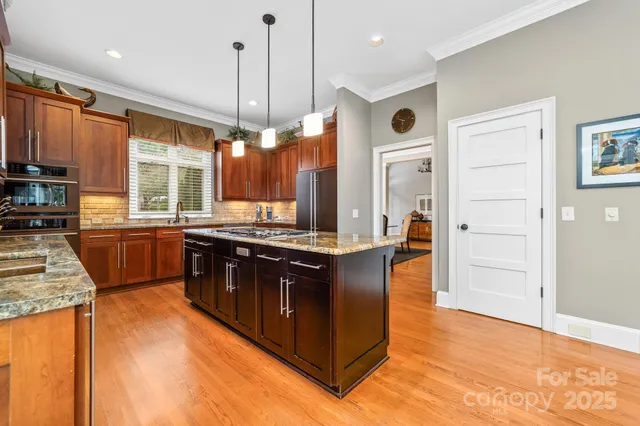 a kitchen with stainless steel appliances granite countertop a stove a sink and a refrigerator