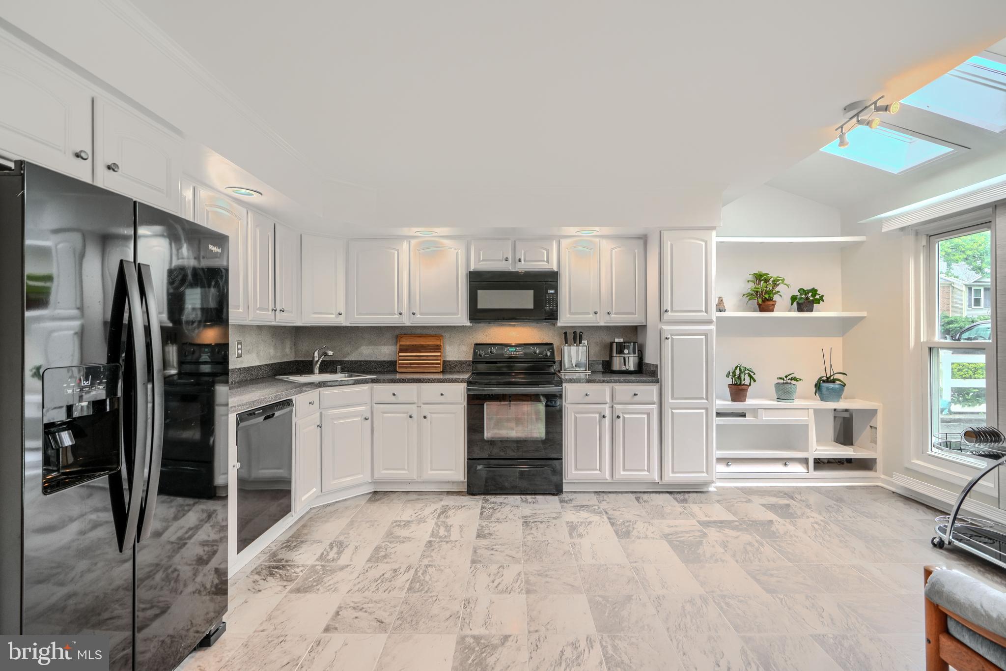 1 Second Tee Court Baltimore, MD 21209 - Photo 11 of 41 a kitchen with granite countertop a refrigerator oven a sink dishwasher and white cabinets with wooden floor