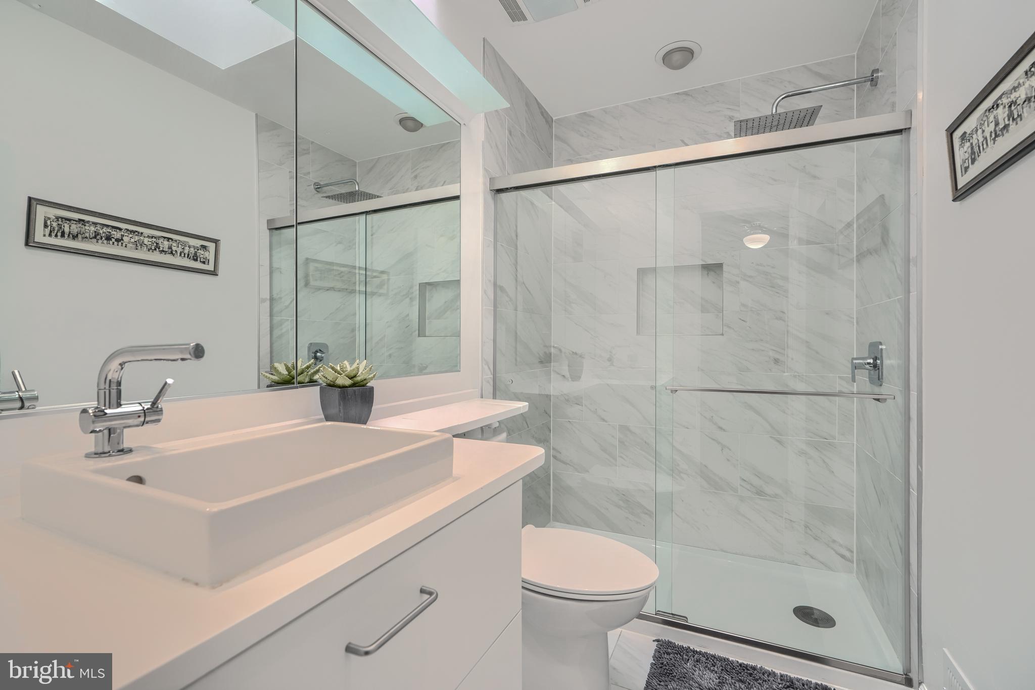 1 Second Tee Court Baltimore, MD 21209 - Photo 21 of 41 a bathroom with a sink toilet a mirror and shower