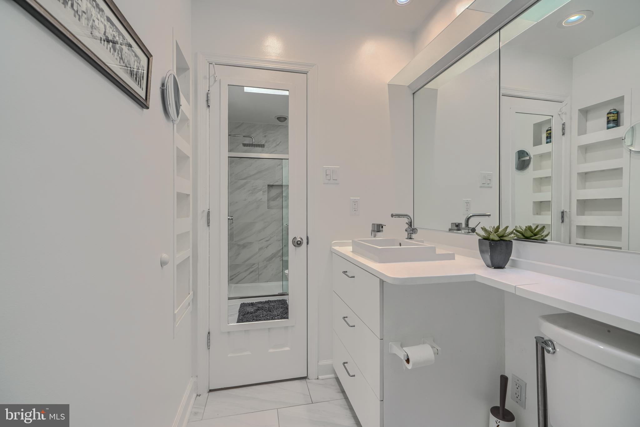 1 Second Tee Court Baltimore, MD 21209 - Photo 23 of 41 a bathroom with a sink a mirror and a shower