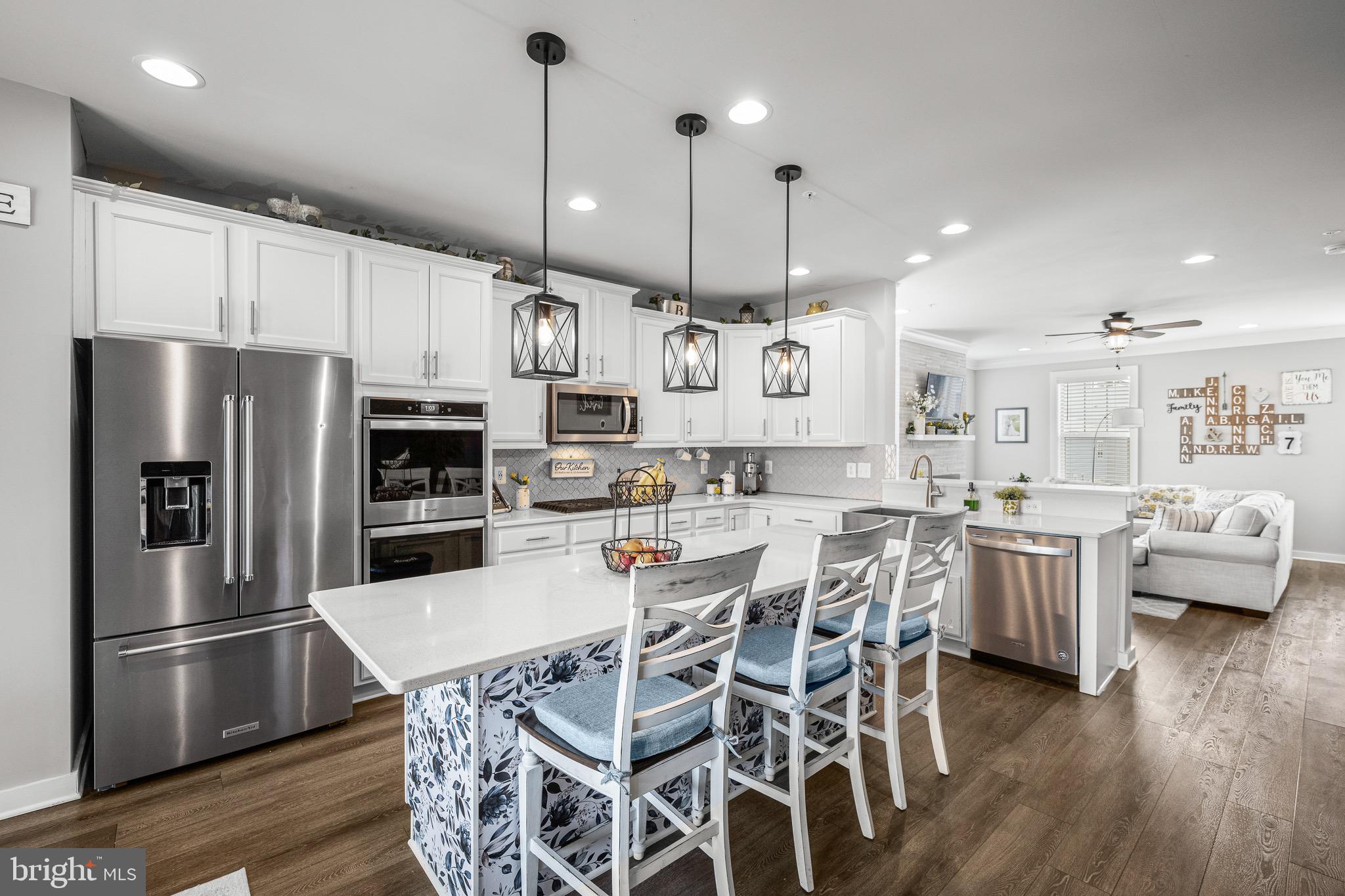 3451 Flatwoods Drive Frederick, MD 21704 - Photo 11 of 43 a kitchen with stainless steel appliances kitchen island granite countertop a refrigerator a stove a kitchen island with a dining table and chairs
