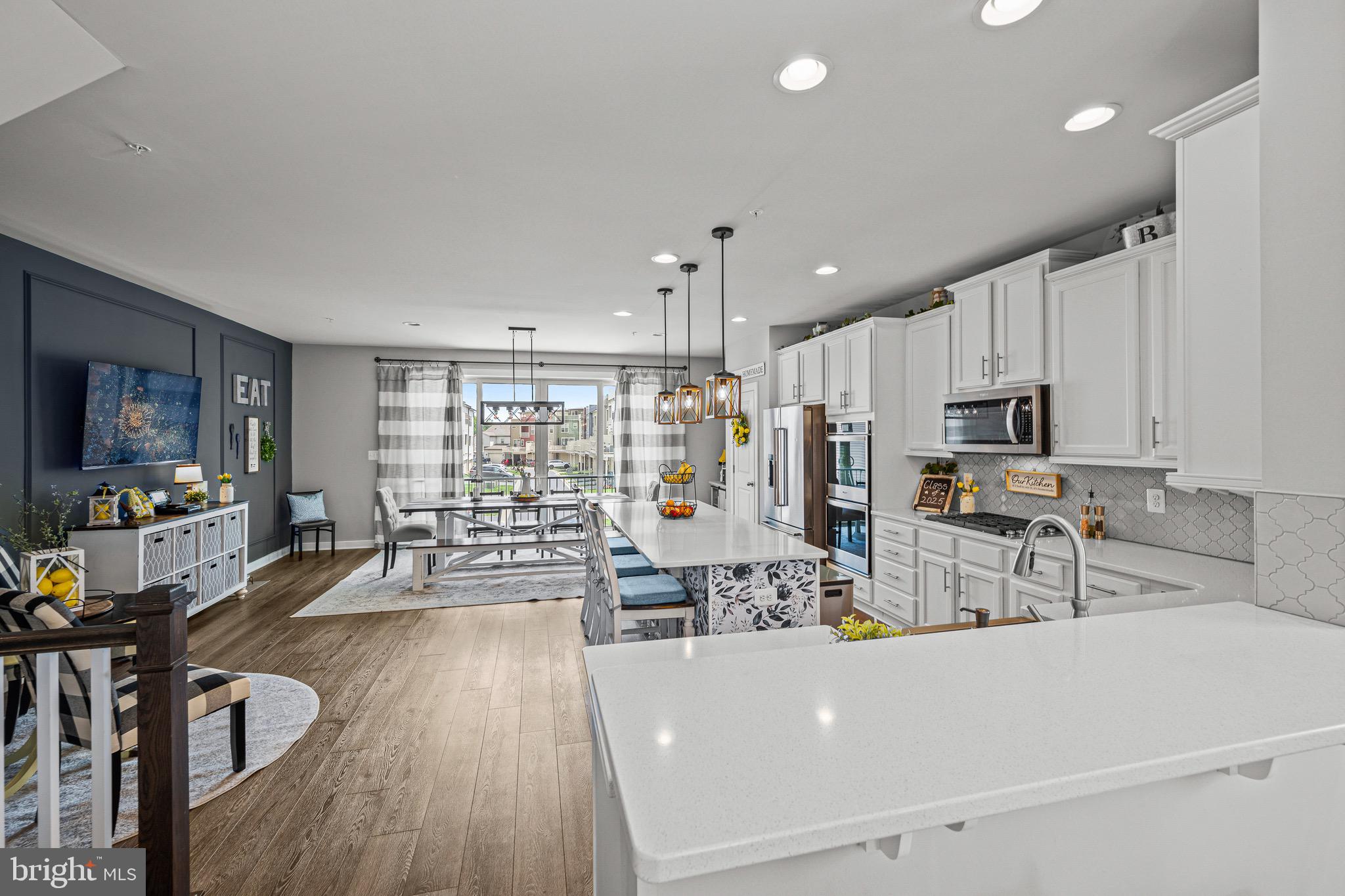 3451 Flatwoods Drive Frederick, MD 21704 - Photo 9 of 43 a living room with stainless steel appliances a dining table wooden floor and a window