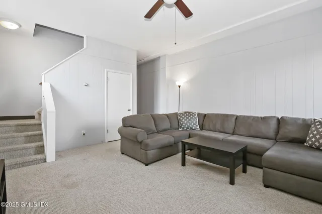 a living room with furniture and a ceiling fan