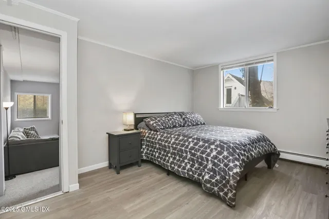 a bedroom with a bed and a painting on the wall