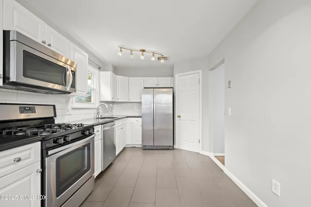 a kitchen with stainless steel appliances a stove microwave and a refrigerator