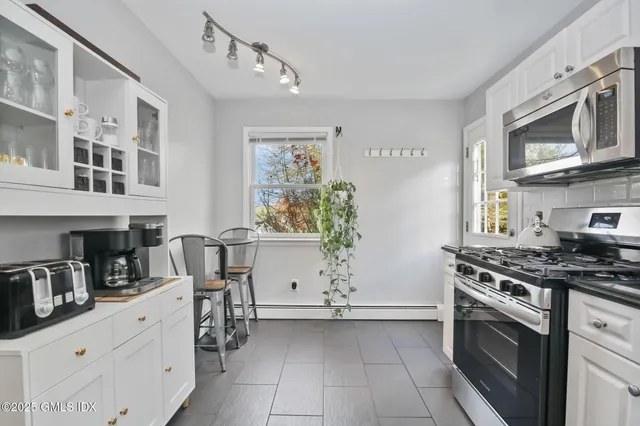 a kitchen with stainless steel appliances white cabinets and a stove top oven