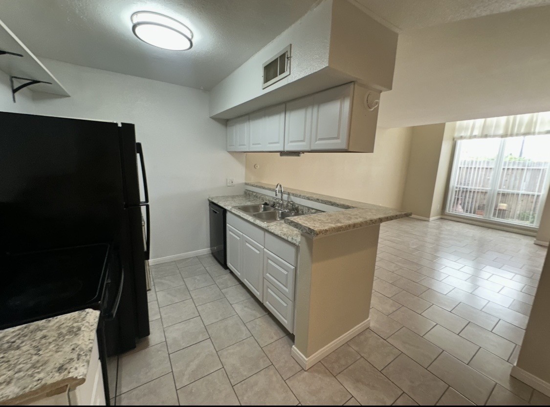 16120 Stuebner Airline Road, Unit 202 Spring, TX 77379 - Photo 5 of 12 a kitchen that has a sink a stove and a refrigerator