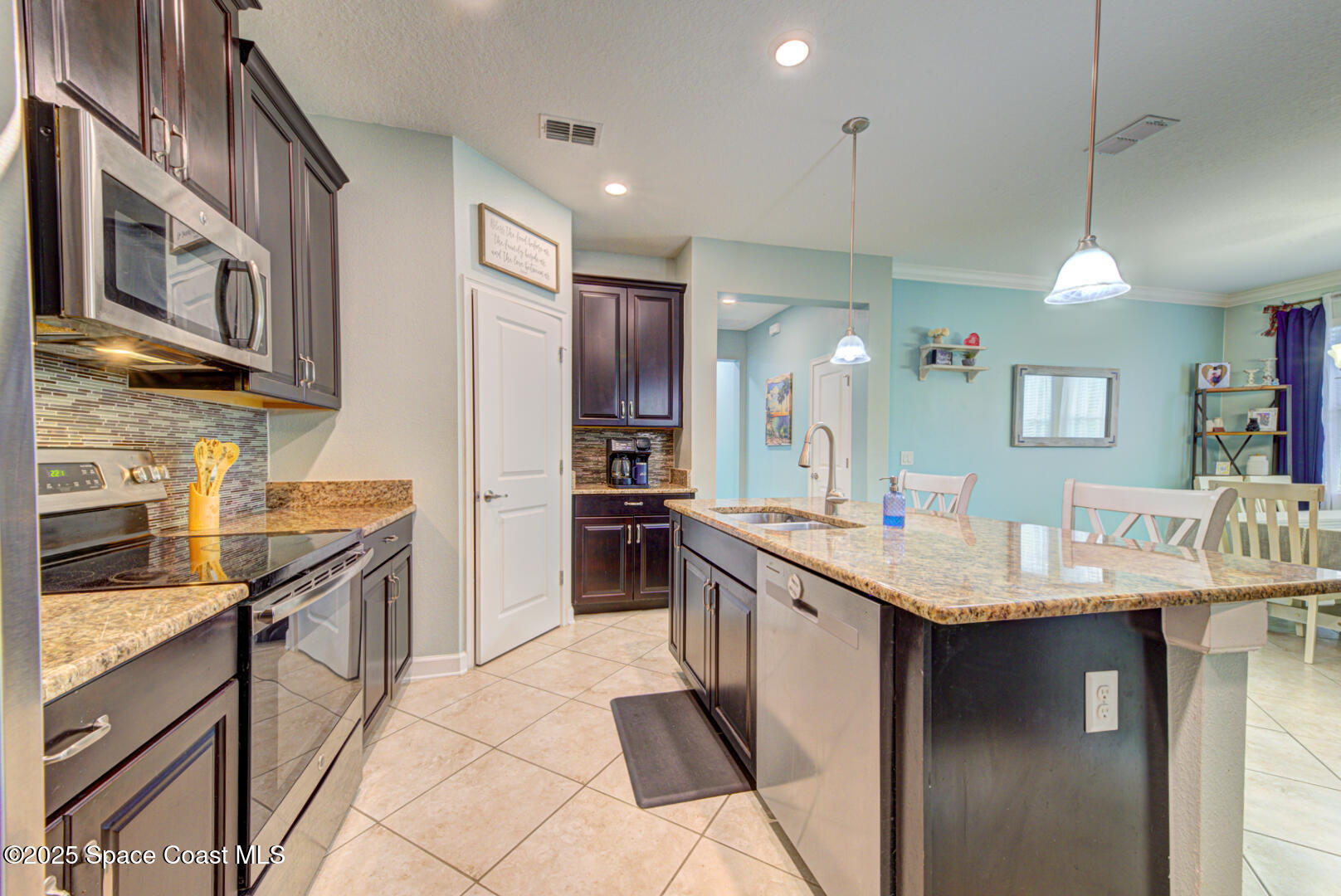 3142 Dark Sky Drive Harmony, FL 34773 - Photo 22 of 54 a kitchen with stainless steel appliances granite countertop a sink and stove