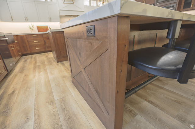 126 North 800 West Mapleton, UT 84664 - Photo 21 of 79 Kitchen view of light wood-type flooring, glass fronted cabinets, two tone cabinets, a kitchen breakfast bar, and a center island