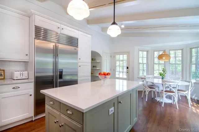 a kitchen with granite countertop white cabinets and window