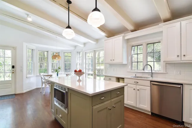 a kitchen with kitchen island a large counter space a sink appliances and living room view