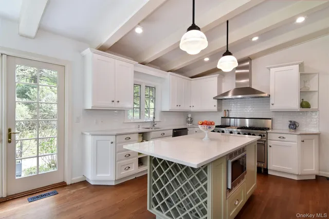 a kitchen with stainless steel appliances granite countertop a sink a stove and a wooden floors