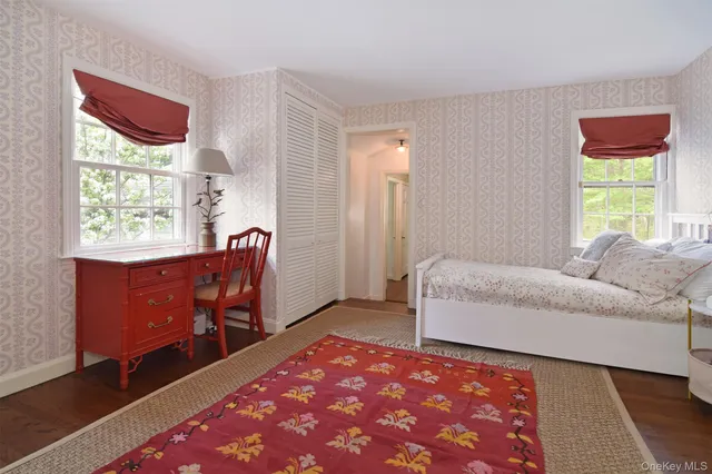 a bathroom with a toilet a sink a mirror and a window