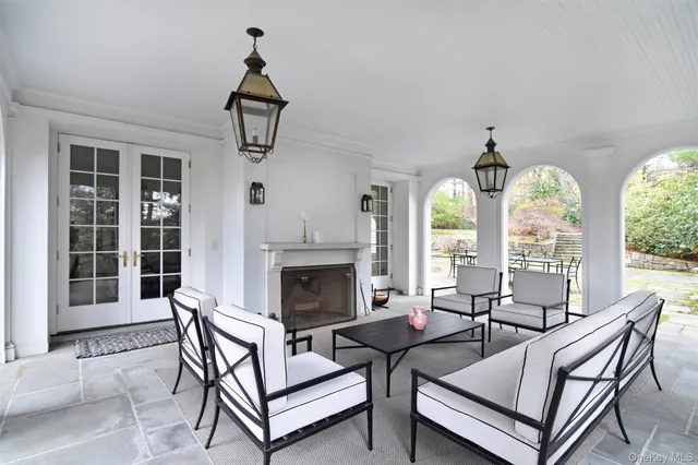 a living room with furniture a fireplace and a floor to ceiling window