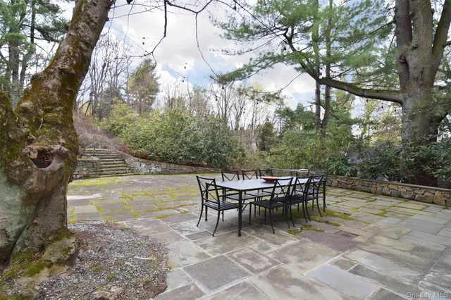 a view of a roof deck with table and chairs and wooden fence
