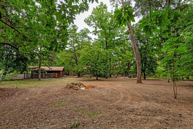 a backyard of a house with trees and wooden fence