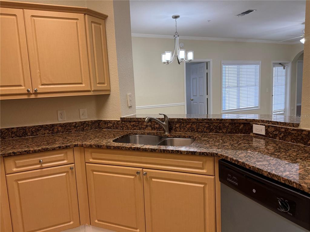 3725 Conroy Road, Unit 2127 Orlando, FL 32839 - Photo 12 of 30 a kitchen with granite countertop stainless steel appliances white cabinets and a sink