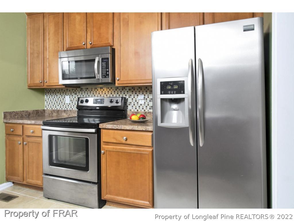5913 Hunting Ridge Road Hope Mills, NC 28348 - Photo 10 of 20 a kitchen with stainless steel appliances granite countertop a refrigerator and a stove top oven