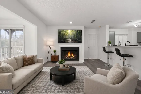 a living room with furniture a fireplace and a flat screen tv