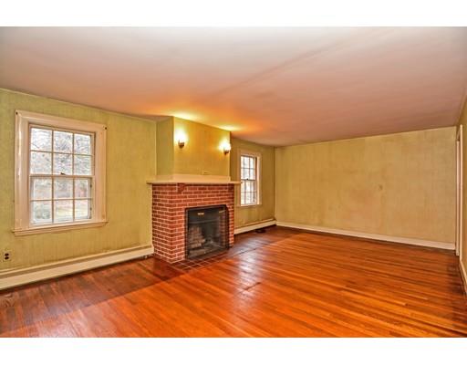 245 Great Road Stow, MA 01775 - Photo 6 of 35 an empty room with wooden floor fireplace and windows