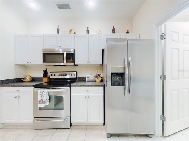 a kitchen with stainless steel appliances white cabinets and a refrigerator