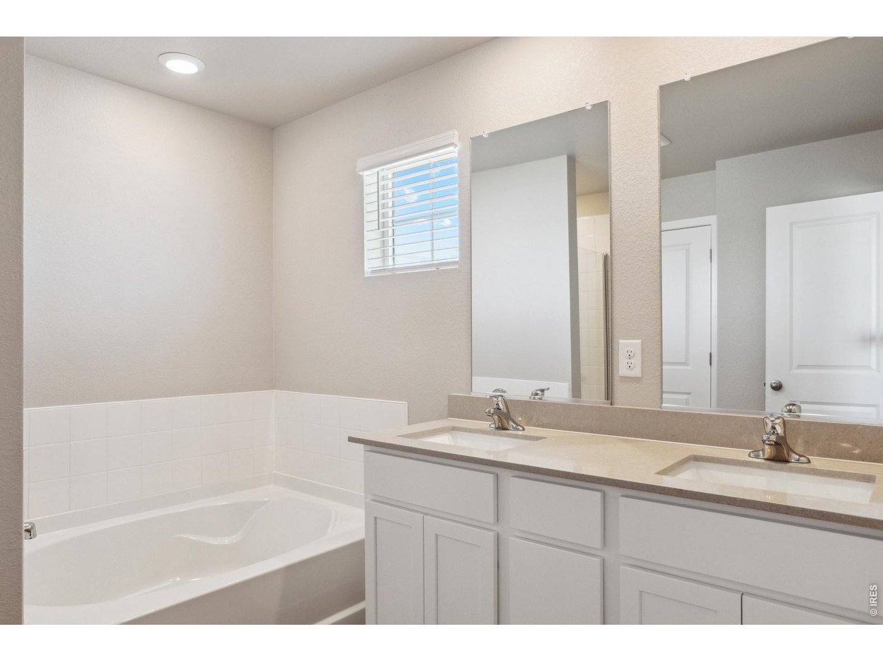 7465 Slate Place Frederick, CO 80530 - Photo 11 of 28 a bathroom with a tub a sink and mirror
