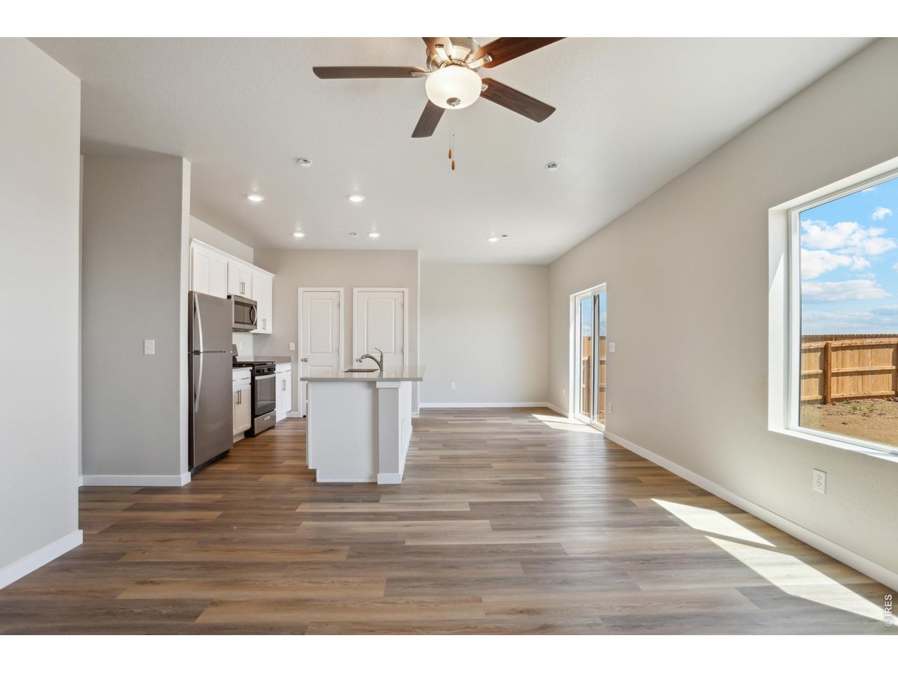 7465 Slate Place Frederick, CO 80530 - Photo 7 of 28 a view of kitchen with refrigerator and wooden floor