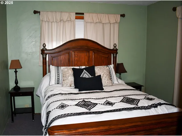 a bed sitting in a bedroom next to a window with a mirror