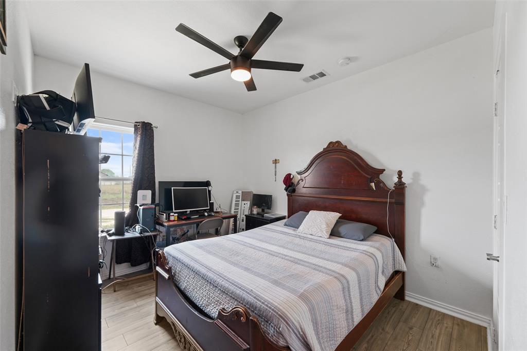 0 Ewing Road Ferris, TX 75125 - Photo 12 of 29 Room featuring wood-finish flooring, a window with exterior views, and a ceiling fan with integrated lighting