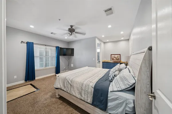 a spacious bedroom with a bed and a flat screen tv