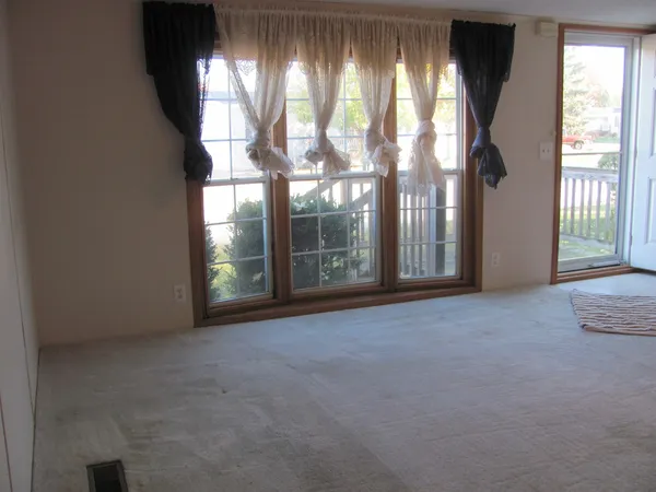 a view of an empty room with windows and a balcony