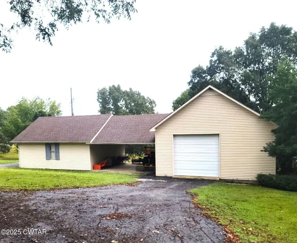 a view of a house with a big yard and large trees