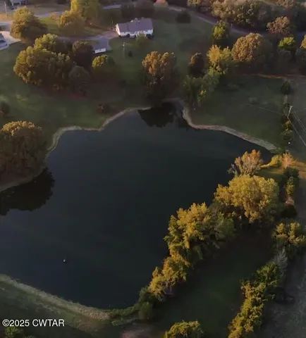 an aerial view of a house with garden space and lake view