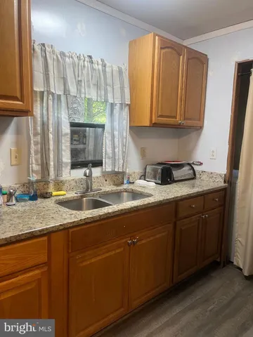 a kitchen with stainless steel appliances kitchen island granite countertop a sink refrigerator and cabinets