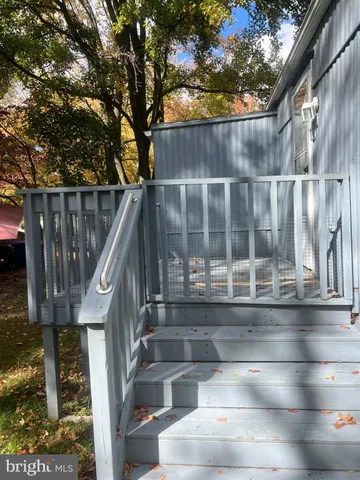 a view of backyard with large tree and wooden fence