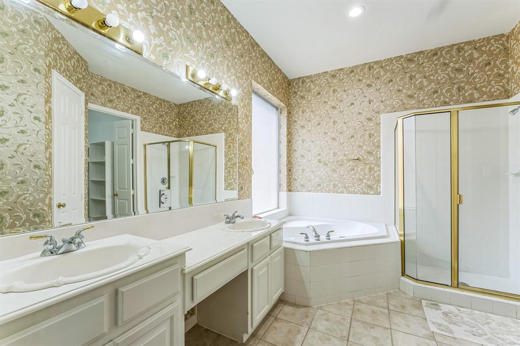 1611 Long Prairie Court Allen, TX 75002 - Photo 17 of 32 a bathroom with a bathtub sink and mirror
