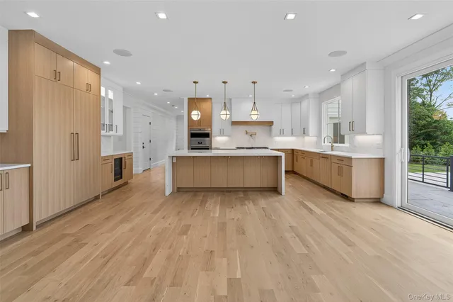a kitchen with white cabinets and wooden floor