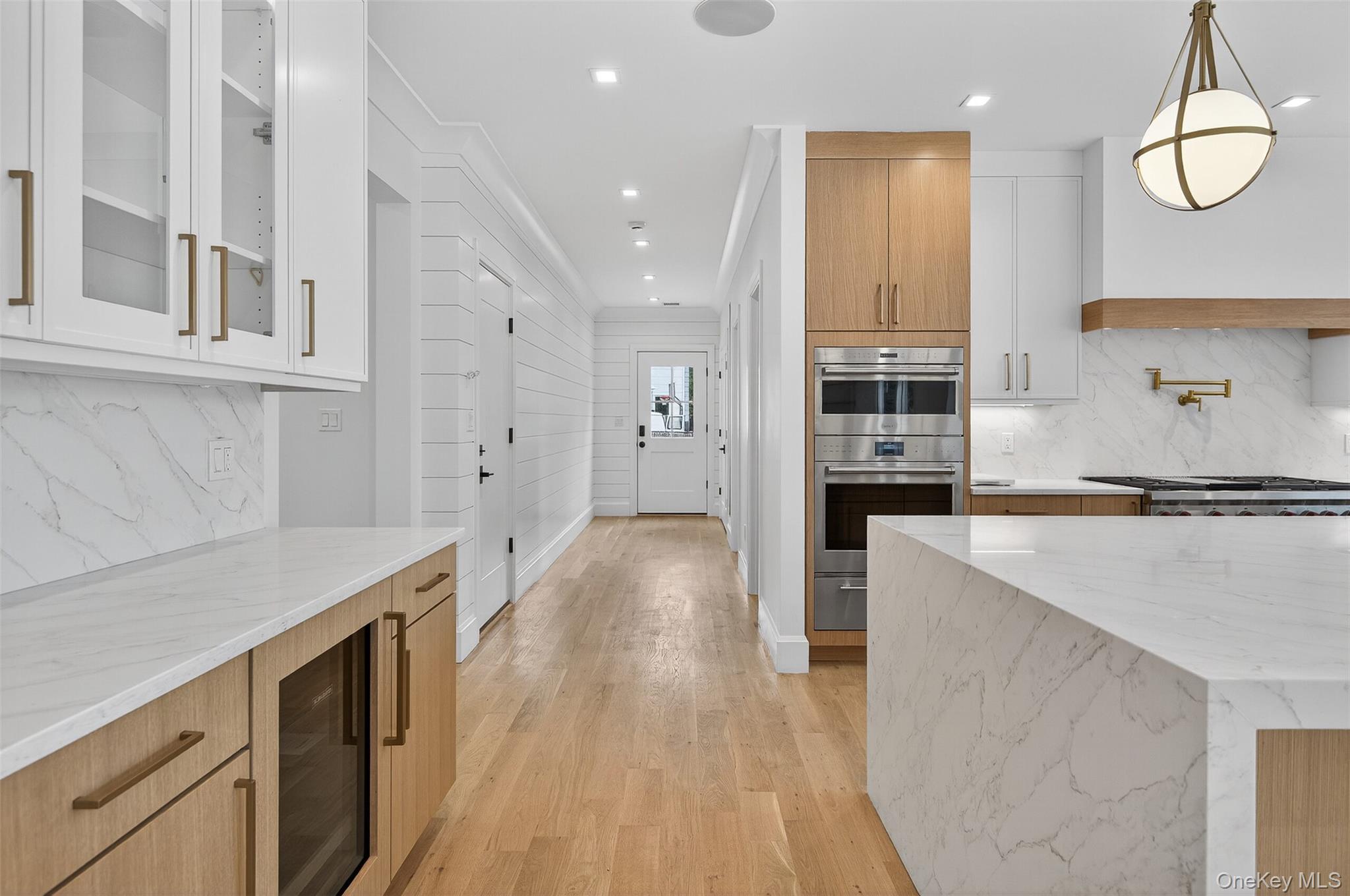 32 A Pine Road Syosset, NY 11791 - Photo 18 of 46 a kitchen with white cabinets and wooden floor