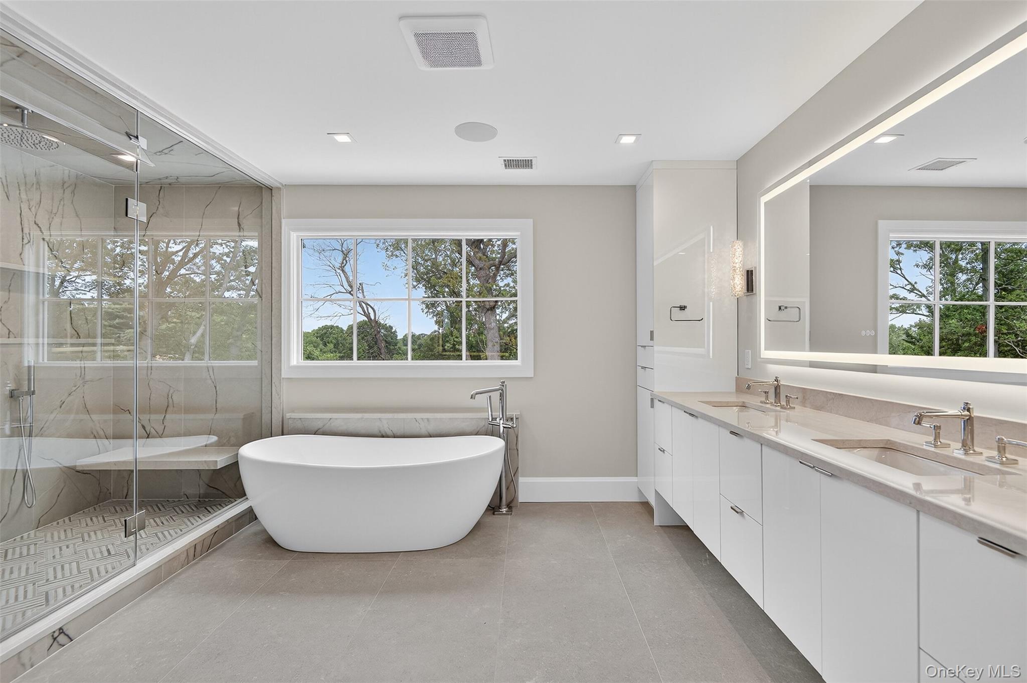 32 A Pine Road Syosset, NY 11791 - Photo 26 of 46 a spacious bathroom with a double vanity sink large mirror and a bathtub