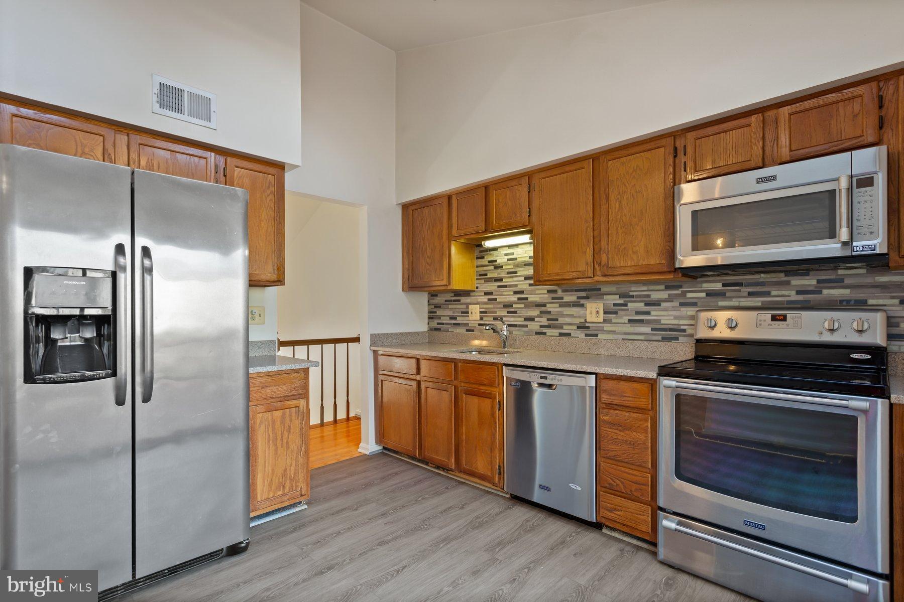 12907 Hawkshead Terrace Silver Spring, MD 20904 - Photo 11 of 30 a kitchen with stainless steel appliances granite countertop a stove a refrigerator and a microwave