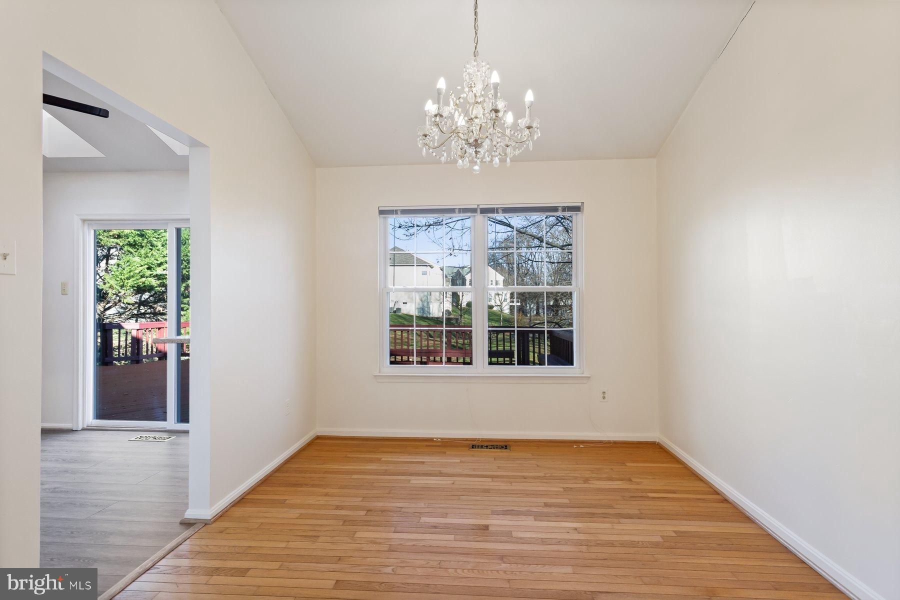 12907 Hawkshead Terrace Silver Spring, MD 20904 - Photo 13 of 30 a view of an empty room with wooden floor and a chandelier
