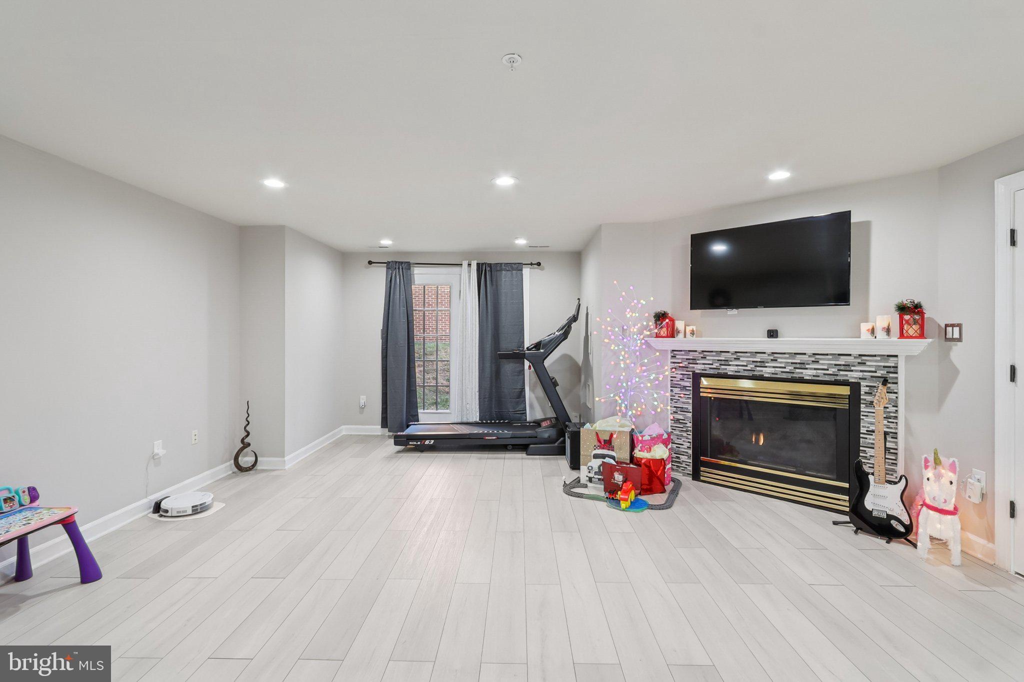 14209 Parker Farm Way Silver Spring, MD 20906 - Photo 6 of 57 a living room with furniture a flat screen tv and a fireplace