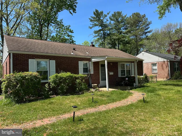 a front view of a house with a yard and trees