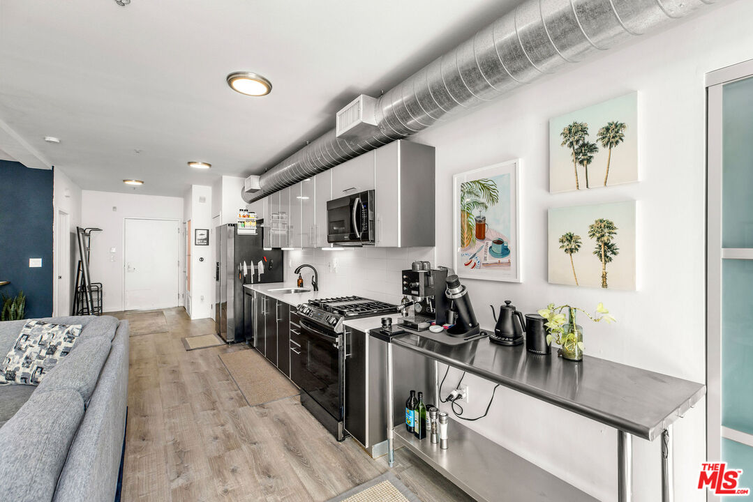4215 Glencoe Avenue, Unit 206 Marina del Rey, CA 90292 - Photo 8 of 21 a kitchen with stainless steel appliances granite countertop a refrigerator a stove a sink dishwasher and wooden cabinets with wooden floor