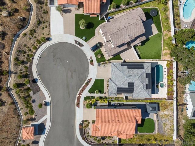 an aerial view of a house with garden space and a fountain