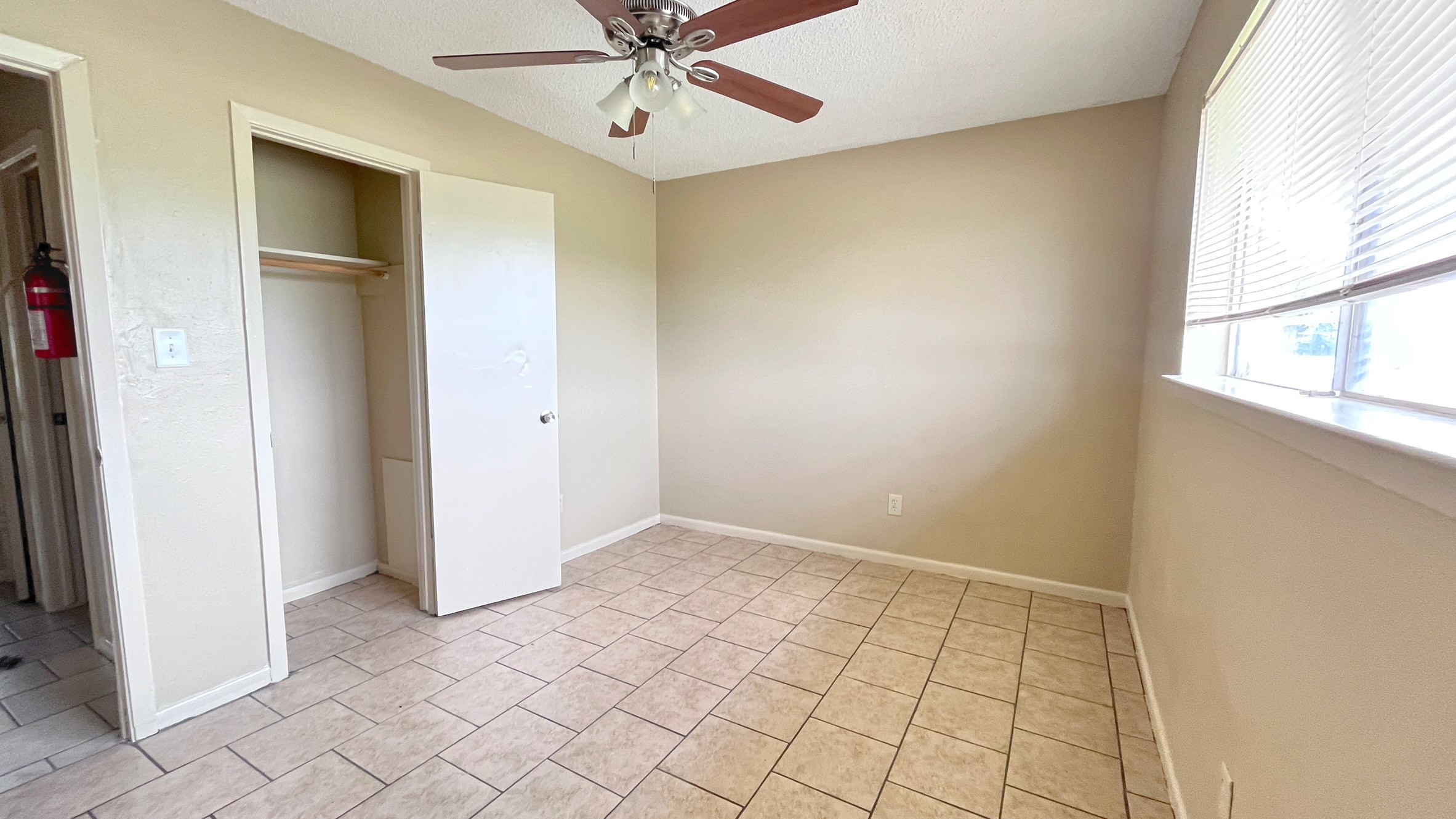 3021 Sycamore Avenue, Unit 1 Bay City, TX 77414 - Photo 6 of 9 an empty room with windows and fan